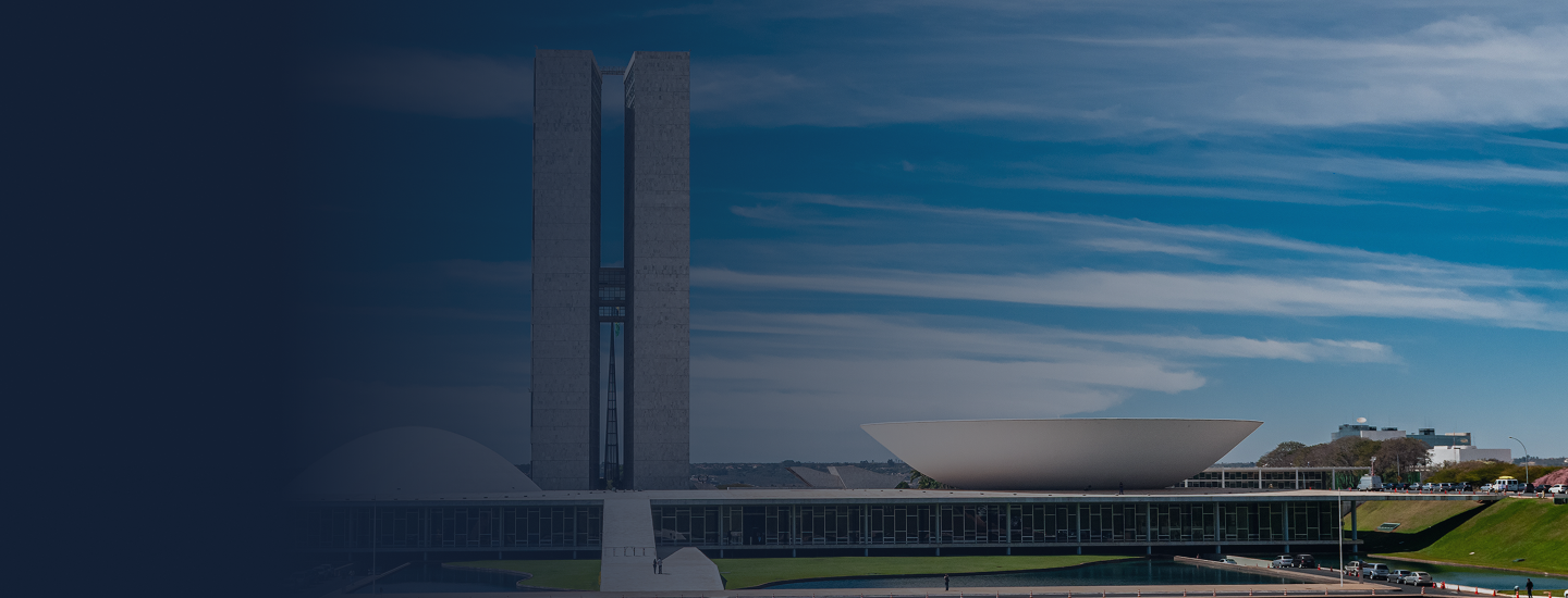 Fachada do Congresso Nacional em Brasília, com as duas torres e as cúpulas da Câmara e do Senado sob céu azul.